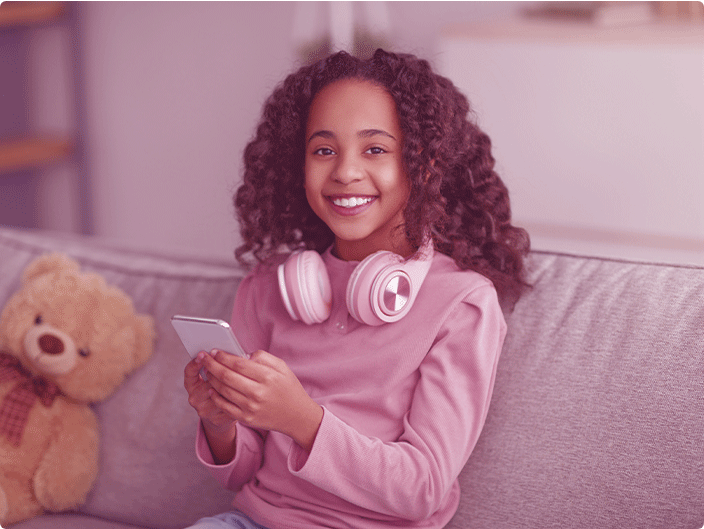 menina com fone e um celular na mão dando um sorriso