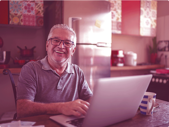 senhor mexendo em um notebook e sorrindo