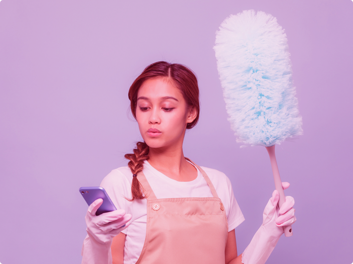 mulher olhando no celular com um produto para limpeza