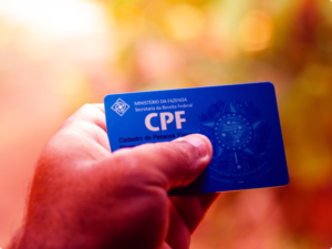 homem segurando o documento de cpf na sua mão