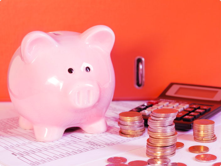 Porquinho de dinheiro ao lado de uma calculadora para ilustrar o artigo sobre 12 dicas para economizar dinheiro no seu dia a dia