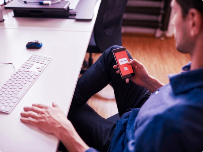 Homem com seu celular e seu computador aprendendo pelo Serasa premium a como trocar a senha da internet wi-fi