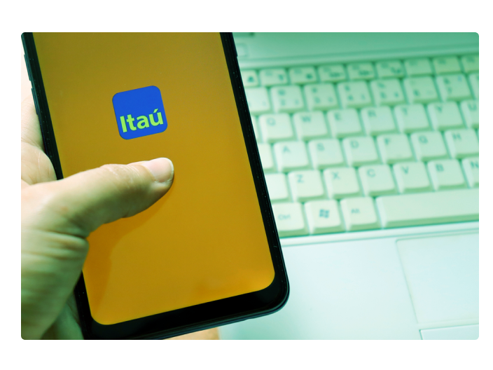 Segurando o celular acessando o aplicativo do itáu para saber mais de como conseguir um cartão itaú personnalité