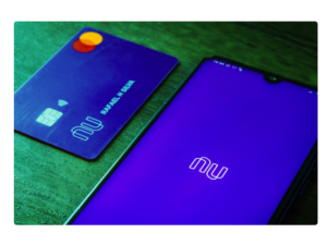 Celular no aplicativo do nubank e cartão ao lado para ilustrar o artigo de como pedir um cartão nubank