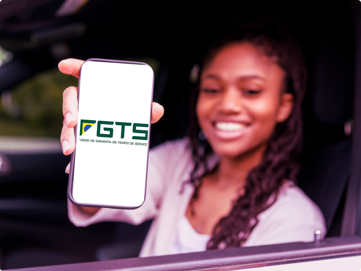 Mulher sorrindo mostrando o celular com o logo do FGTS para ilustrar o empréstimo FGTS sobre como funciona e como conseguir