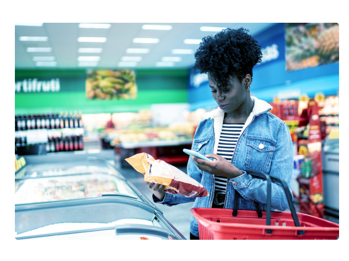 Mulher no mercado controlando seus gastos após ver um artigo sobre a diferença entre o consumo e o consumismo