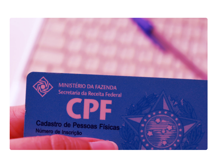 Mulher segurando seu documento cpf e vendo como funciona o sistema antifraude da serasa