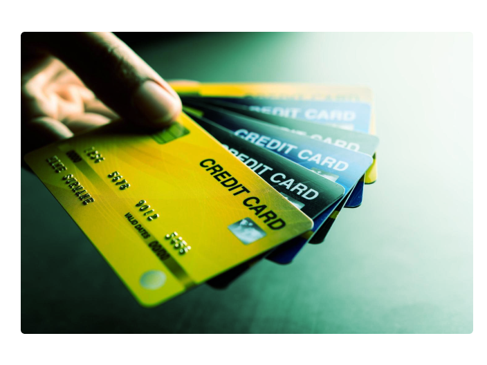 Mulher segurando diversos tipos de cartão de crédito para pessoa com o nome sujo para ensinar a como pedir um
