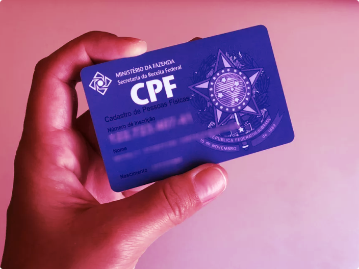 Homem segurando seu documento CPF em mãos para ilustrar o artigo da serasa que fala sobre os geradores de CPFs aleatórios