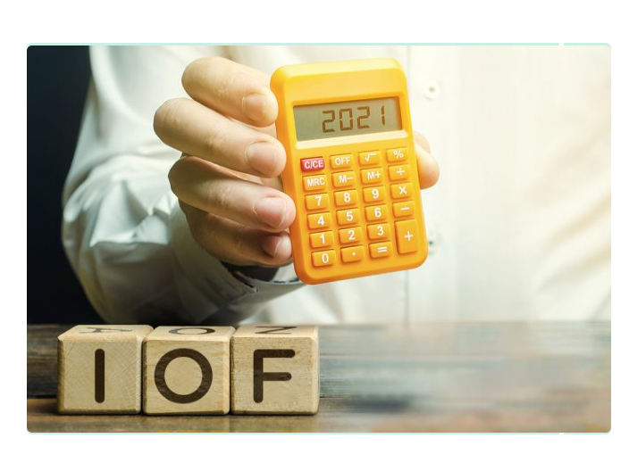 homem segurando a calculadora e pesquisando sobre a tabela do IOF e tudo o que está afetando este imposto