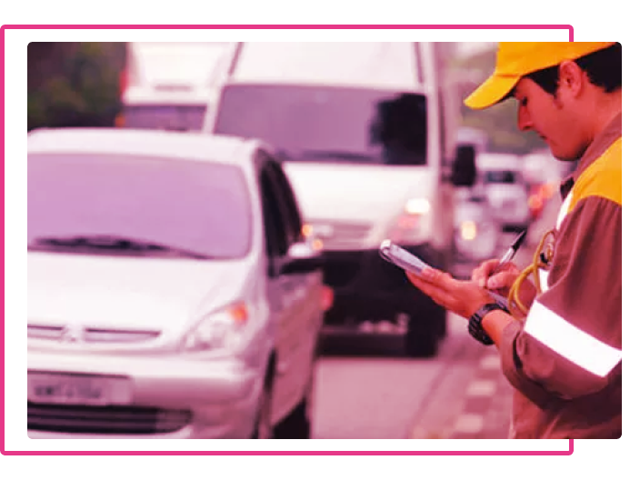 Foto de um guarda multando um carro para ilustrar o texto sobre tipos de multa de trânsito
