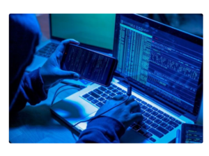 Hacker utilizando seu celular e notebook para fazer o vazamento de cpf e outros dados das pessoas